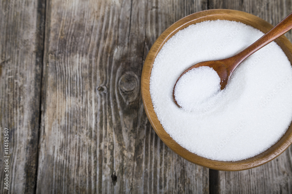 Sugar and spoon in a wooden bowl Sugar and spoon in a wooden bowl