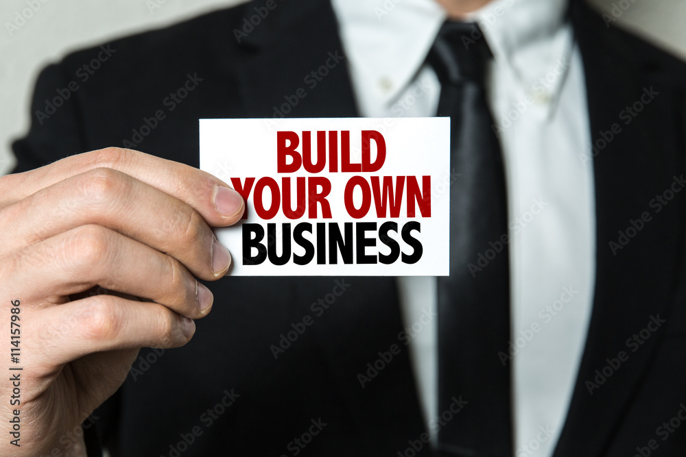 Business man holding a card with the text: Build Your Own Business