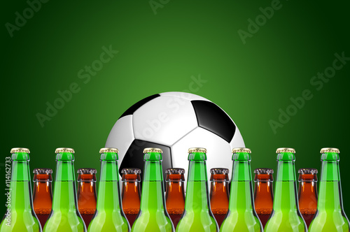 Glass, bottles of beer and soccer ball on a green background