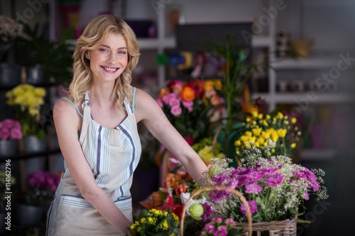 Happy female florist standing in flower shop