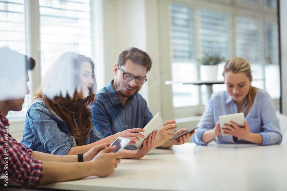 Business people using technologies in board room Business people using technologies in board room