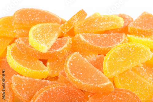 Heap of orange and lemon candy slices on a white