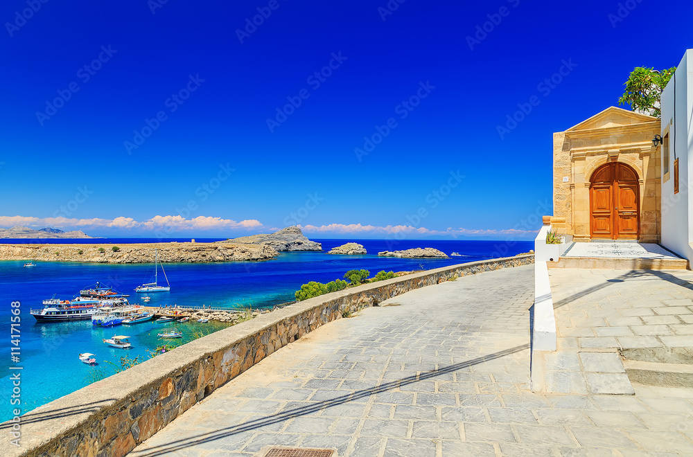 beautiful house in Lindos on the background of the bay, yachts and ships of Rhodes Greece