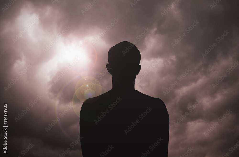 Young man standing around the dramatic sky before storm Young man standing around the dramatic sky before storm