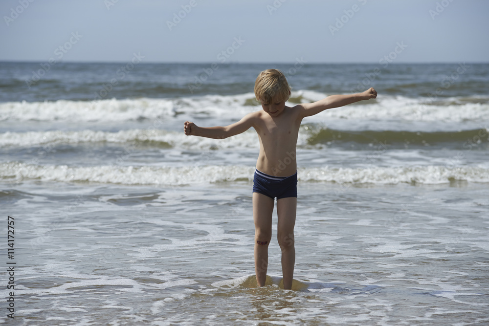 Child blond boy playing on sandy beach, summer time Child blond boy playing on sandy beach, summer time