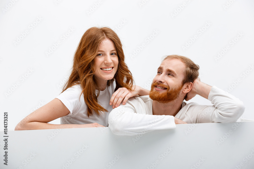 Funny redhead boy and girl posing at white table Funny redhead boy and girl posing at white table