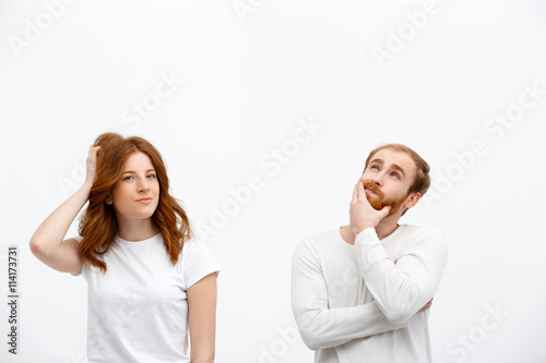 Funny redhead girl with boy dressed in white t-shirt standing o