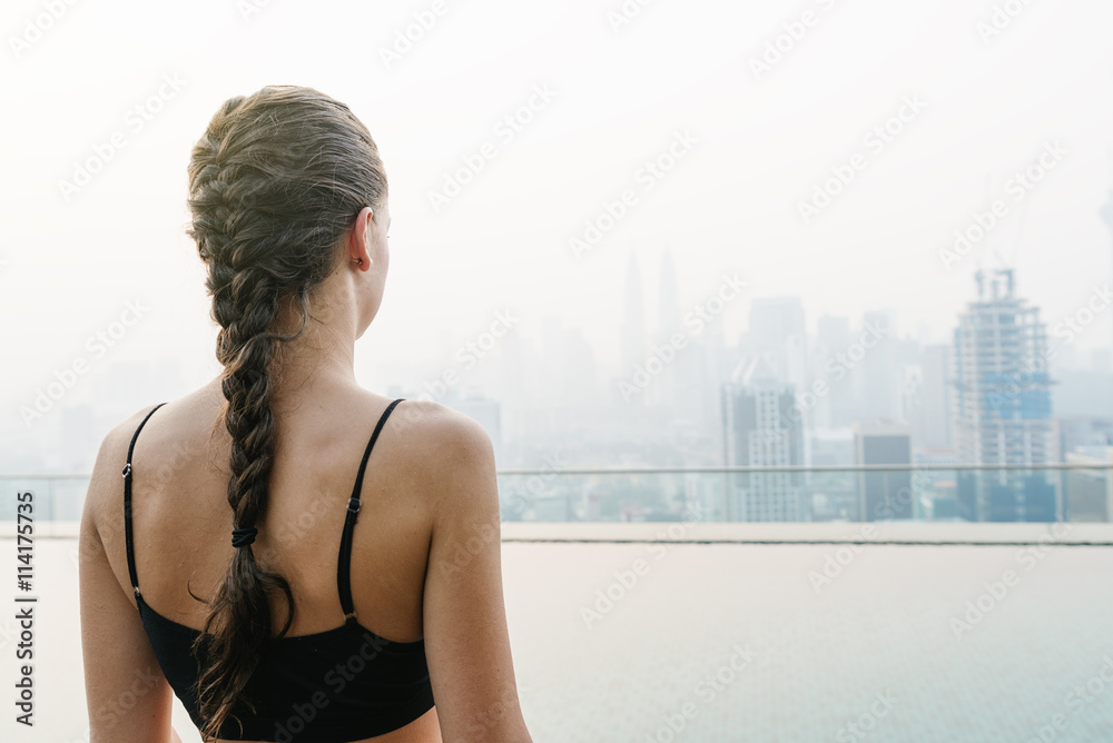 Relaxed young yoga woman in yoga pose near pool.