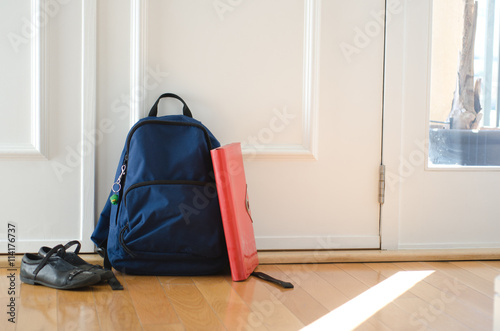 Back to school or ready for school concept with school bag and shoes by front door