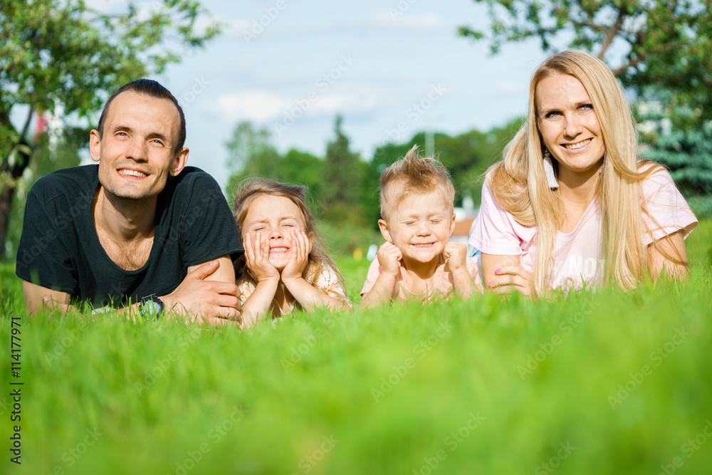 Portrait of happy parents with kids lying at the park Portrait of happy parents with kids lying at the park