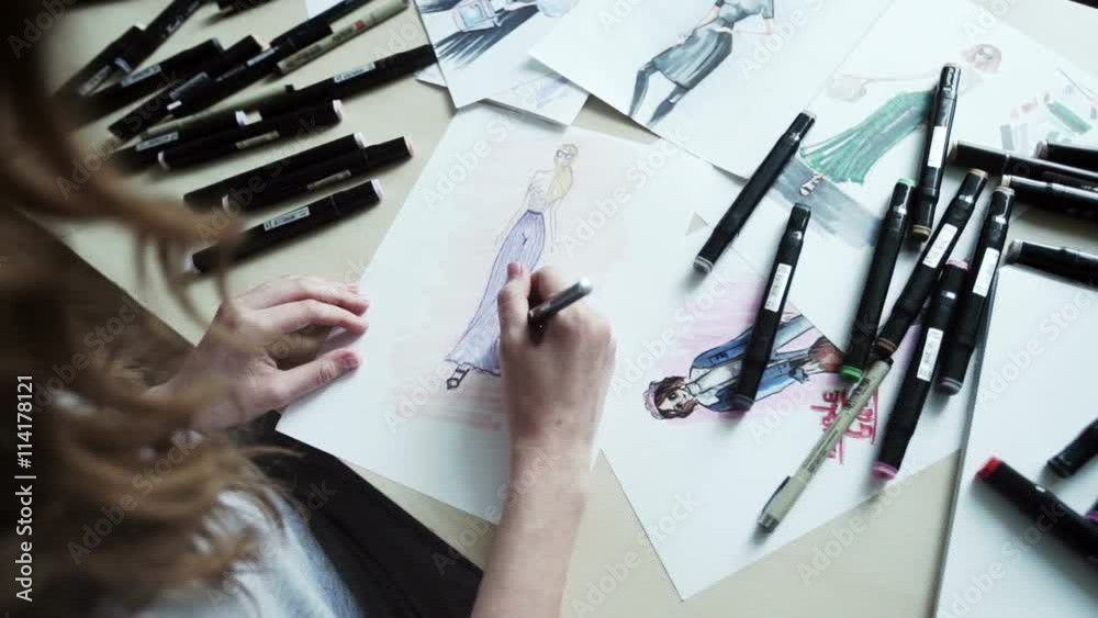 Female fashion designer drawing sketches for clothes