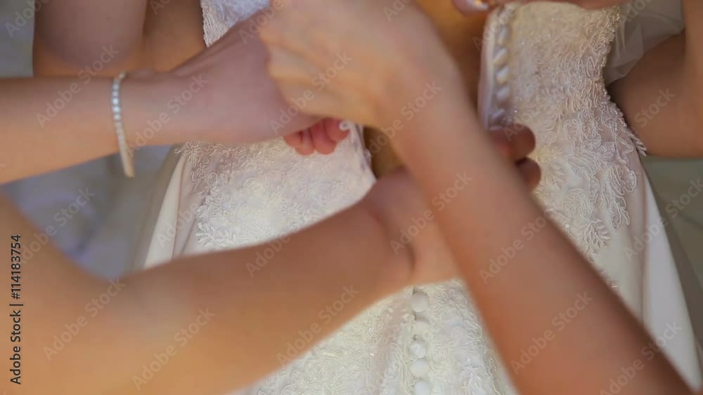 Best friend helps the bride to clasped a wedding dress Best friend helps the bride to clasped a wedding dress