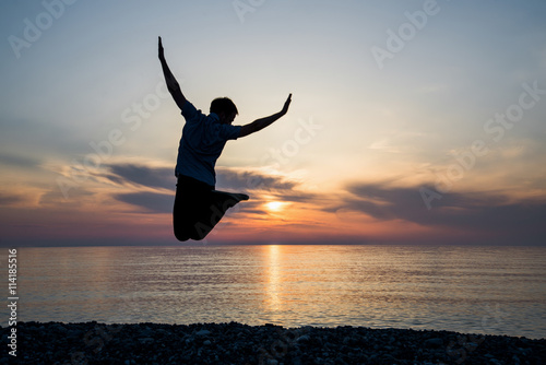 silhouette of teenager jumping in sunset for fun