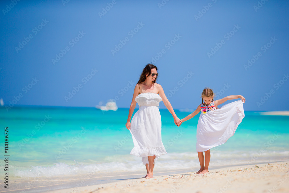 Mother and daughter enjoying time at tropical beach. Happy family on summer holidays at exotic island