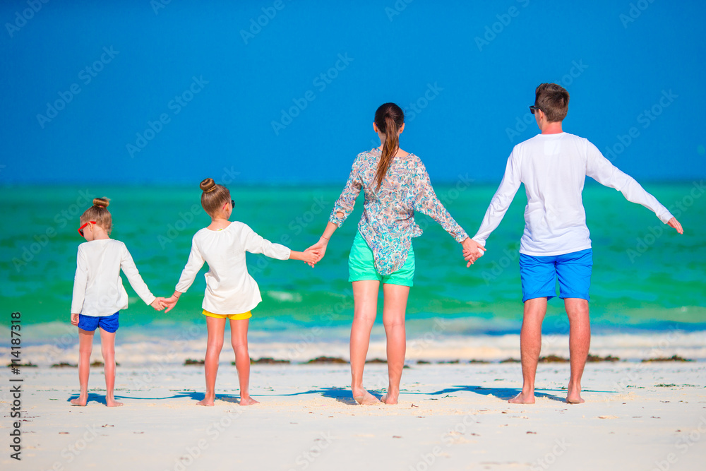 Young family on vacation. Happy father, mother and their active kids having fun on their summer beach holidays Young family on vacation. Happy father, mother and their active kids having fun on their summer beach holidays