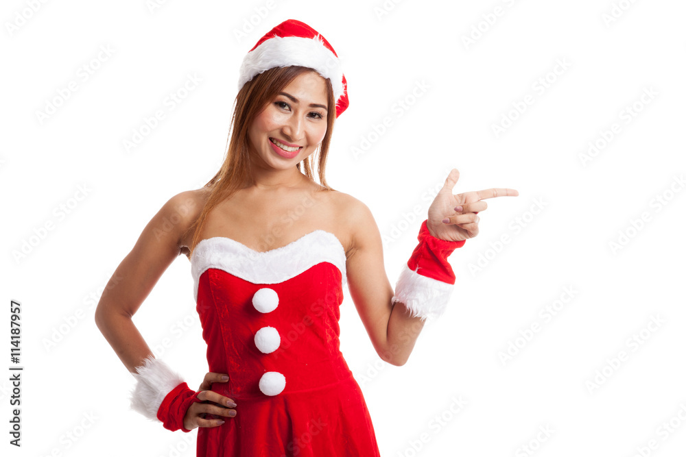 Asian Christmas girl with Santa Claus clothes point to blank spa Asian Christmas girl with Santa Claus clothes point to blank spa