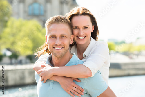 Happy Man Carrying Woman On His Back