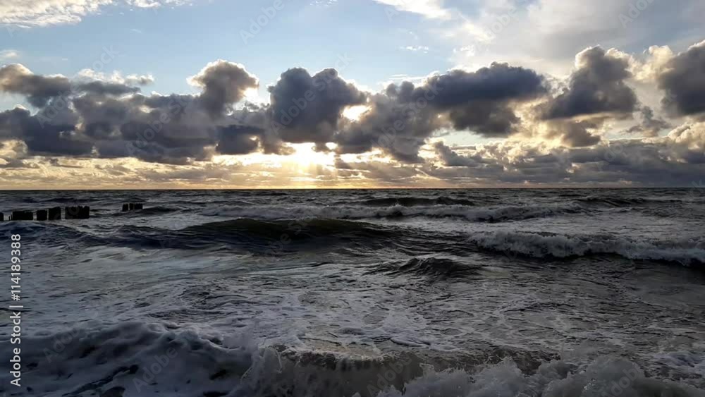 Sunset at Baltic Sea, cloudy sky, small waves Sunset at Baltic Sea, cloudy sky, small waves