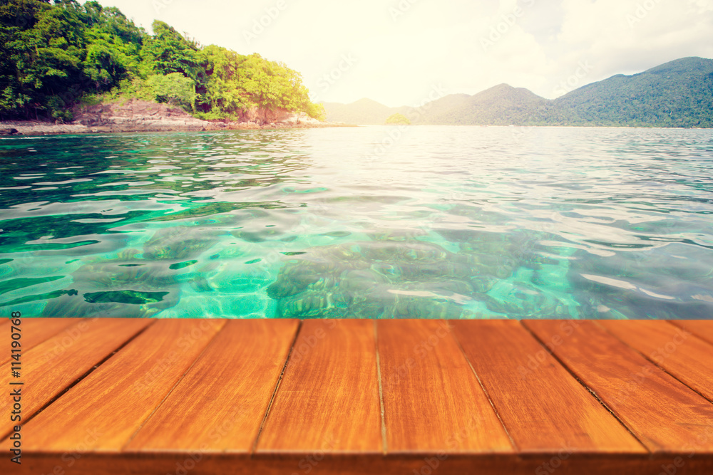 Fototapeta premium Wood table top on beautiful tropical sea background. For display and montage products