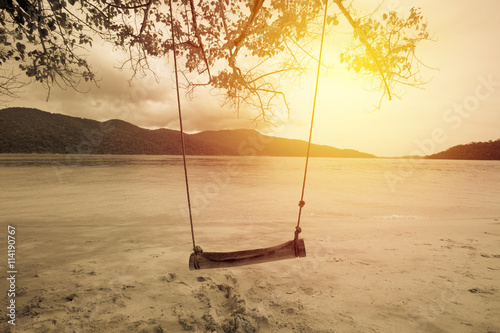 Empty chain swing in tropical beach and sea. vintage filter