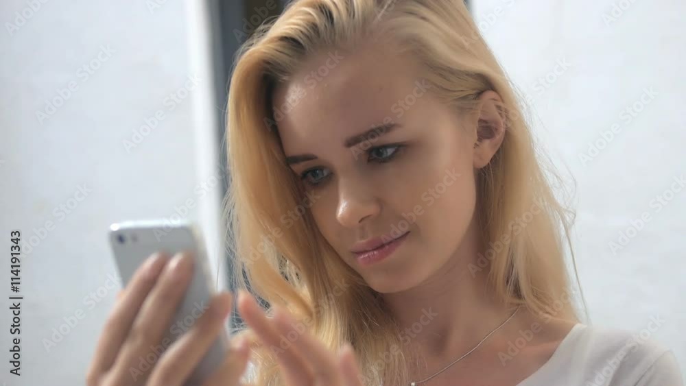 Summer lifestyle portrait of beautiful girl Holding in hand smart phone. Enjoying life and smiling. Nude makeup. Close up Summer lifestyle portrait of beautiful girl Holding in hand smart phone. Enjoying life and smiling. Nude makeup. Close up