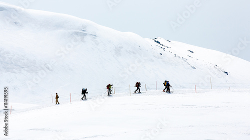 Skiers walking on snow covered mountain ranges © aiaikawa