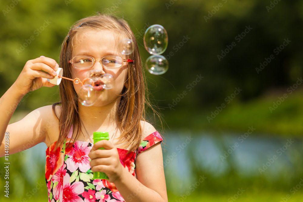 Little girl child blowing soap bubbles outdoor. Little girl child blowing soap bubbles outdoor.
