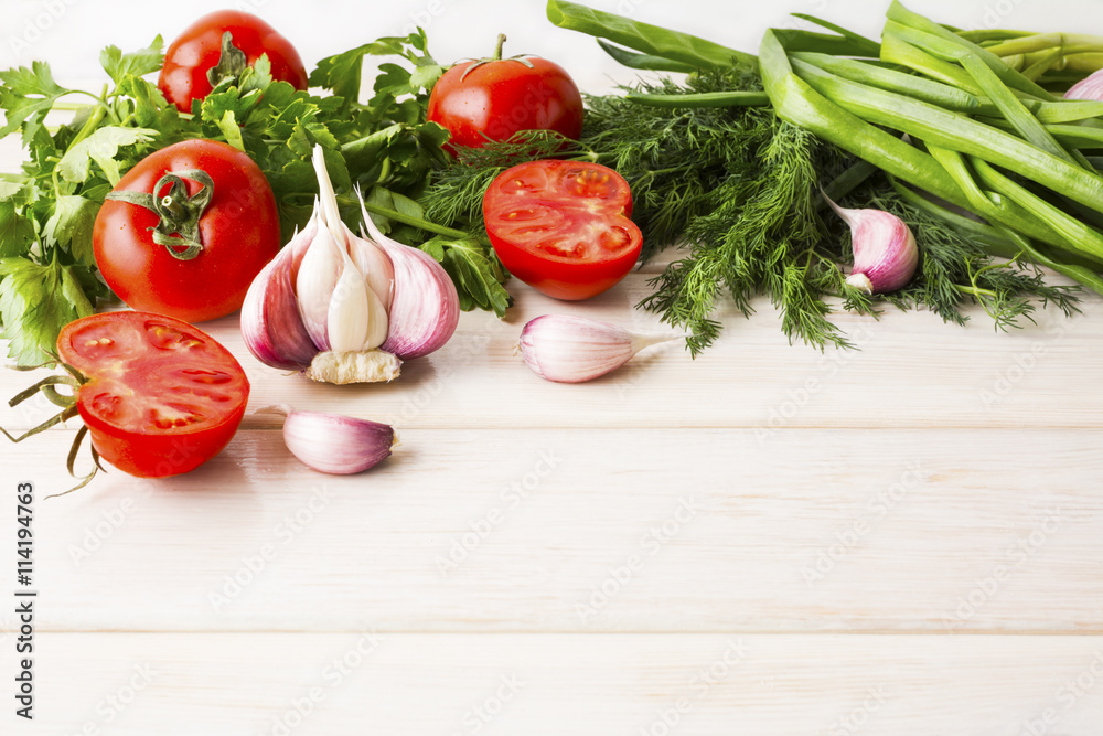 Garlic and tomato on the white wooden background Garlic and tomato on the white wooden background