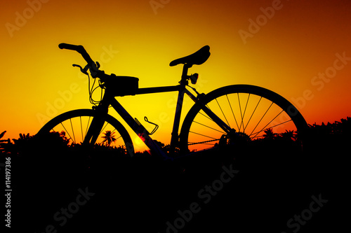 Silhouette bicycles on sunset sky