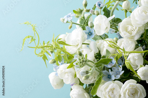 Vászonkép 青い背景と白い薔薇とブルースターとスマイラックス