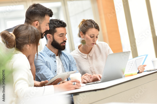 Design team meeting and working on laptop