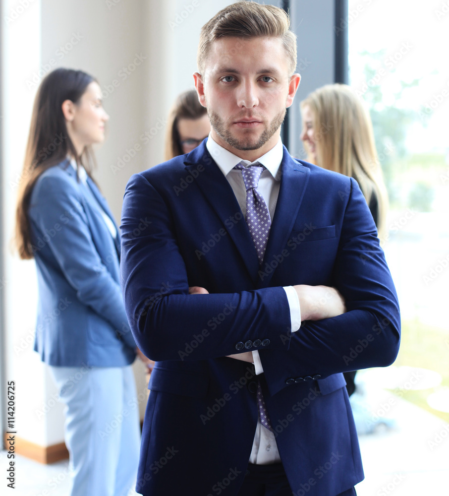 Happy smart business man with team mates discussing in the background Happy smart business man with team mates discussing in the background