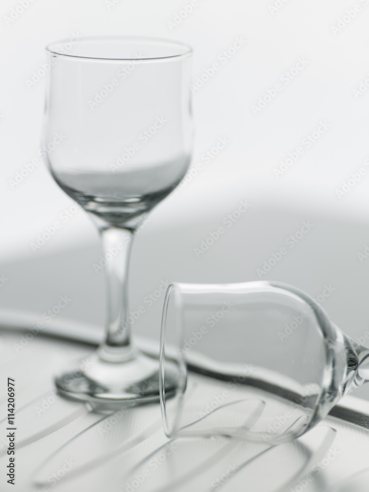 Obraz premium A couple of empty wine glasses, one of them fell.