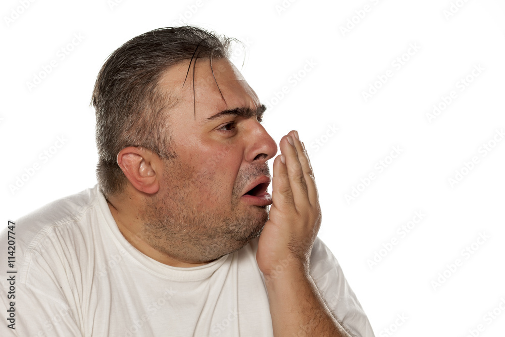 disgusted man checks his breath. disgusted man checks his breath.