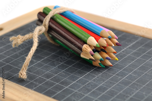 crayons de couleurs ficelé sur ardoise scolaire