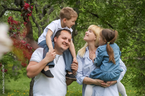 Happy family with two kids having fun in garden