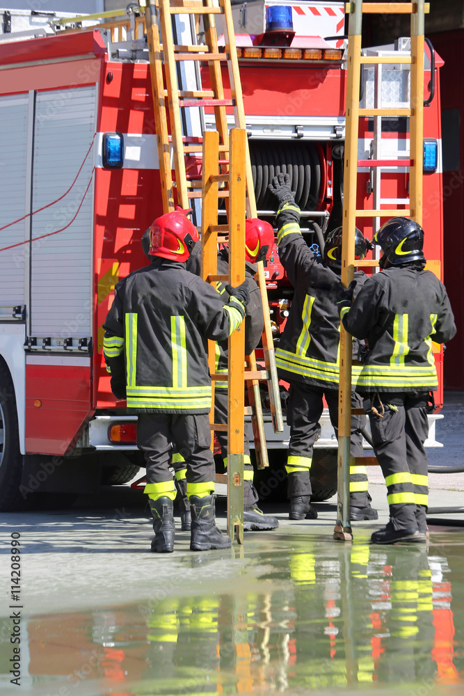 firefighters in action take the ladder from the fire engine