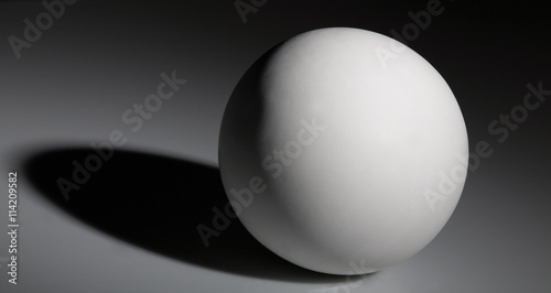 white ball with shadow on gray background