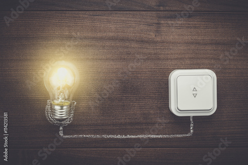 Quadro em tela glowing bulb uniqueness concept on brown wooden background