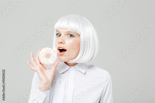 Happy cute young woman holding sweet donut