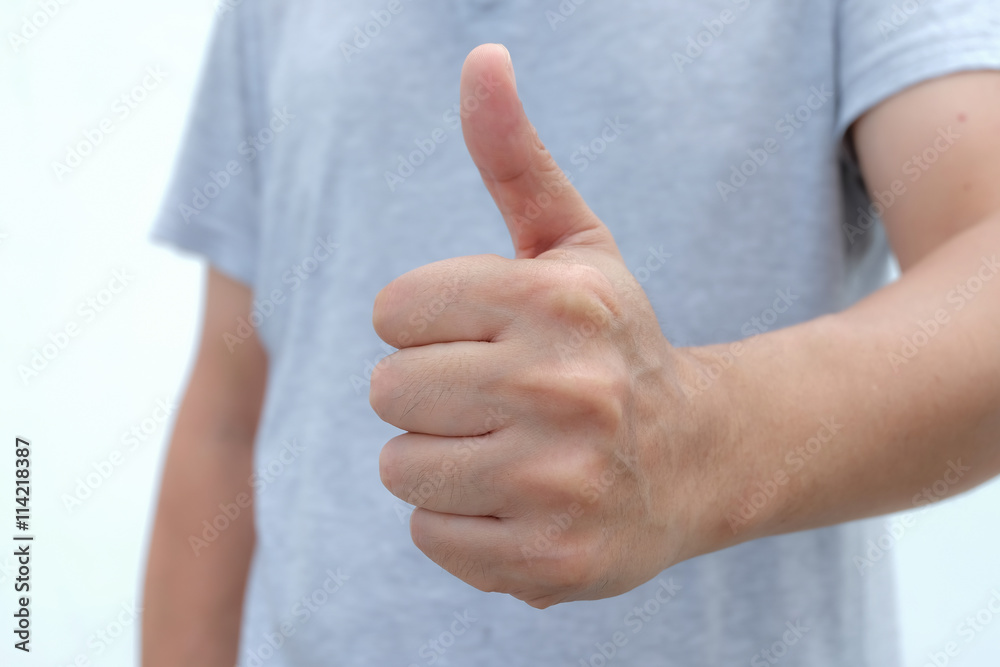Closeup of male hand showing thumbs up sign against white background Closeup of male hand showing thumbs up sign against white background