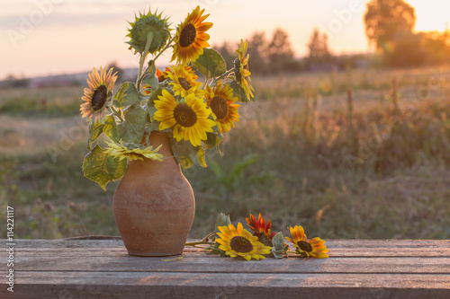 Fototapeta Naklejka Na Ścianę i Meble -  sunflowers in jug at sunset