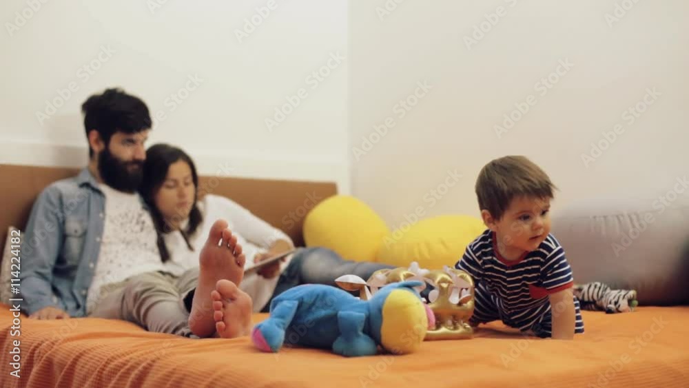Mom and dad relaxing with his baby son on the bed. Happy family concept Mom and dad relaxing with his baby son on the bed. Happy family concept