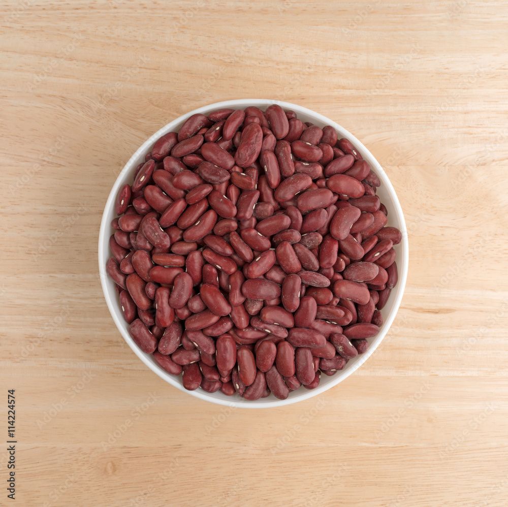 Bowl filled with dark red organic kidney beans top view on a wood table. Bowl filled with dark red organic kidney beans top view on a wood table.