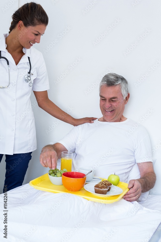Female doctor talking to senior man while having breakfast Female doctor talking to senior man while having breakfast
