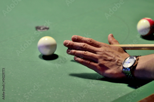 Pool player hits the cue ball photo