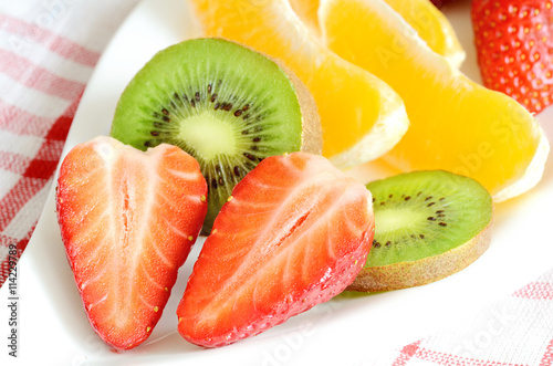 Bowl with fruit salad - pieces of orange, strawberry and kiwi
