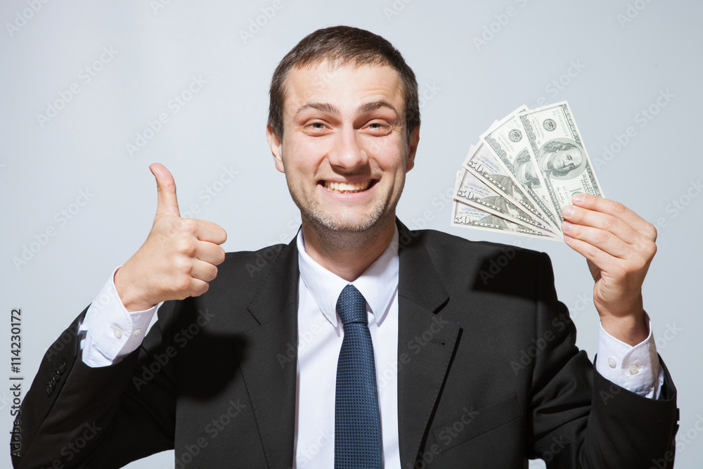Happy businessman holding dollars and showing thumb up sign Happy businessman holding dollars and showing thumb up sign