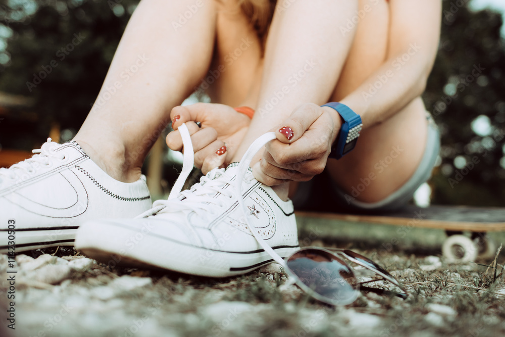 young athletic woman tying shoelaces outdoor