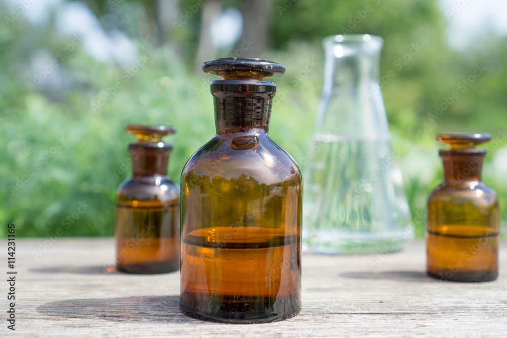 Liquid in chemical ware on a background of plants, fertilizers or pesticides in the garden. Liquid in chemical ware on a background of plants, fertilizers or pesticides in the garden.
